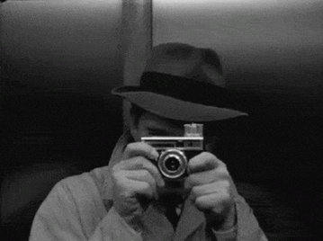 Hombre con sombrero tomando foto.