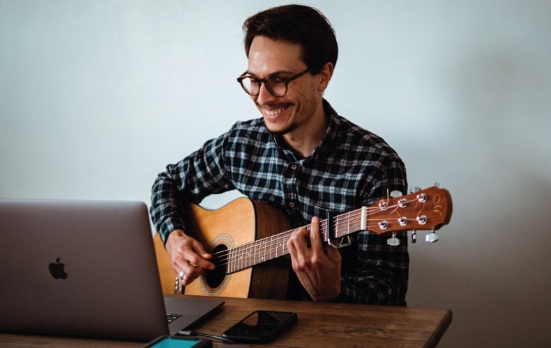 Hombre tocando la guitarra en una quedada virtual